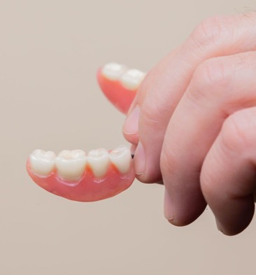 hand holding a denture