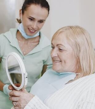 patient with dentures looking in mirror